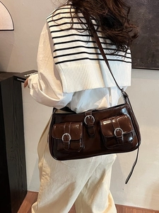 Retro dunkelbraune Leder-Umhängetasche mit Schnallentaschen an einem Model