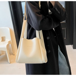 Detailed macro view of cream white lychee pattern leather bucket bag with top handles