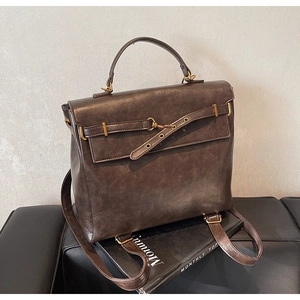 Detail of vintage brown leather backpack showing metallic buckles and oil-wax texture