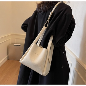 Close-up of white lychee pattern leather bucket bag showing HAMIROO brand texture