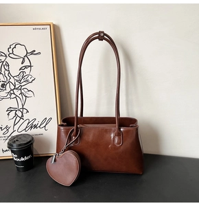 Détail du sac sous l'aisselle marron rétro avec un porte-monnaie amovible en cœur