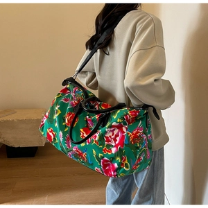 Detail of floral travel bag featuring green canvas print and adjustable shoulder strap