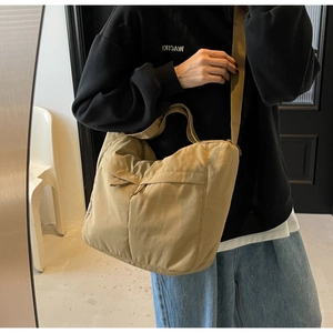 Close-up of khaki nylon tote bag showing lightweight fabric texture and wide shoulder strap
