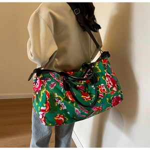 Detailed back view of a large floral travel bag with green print and black straps