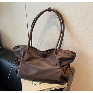 Détail du sac cabas en nylon avec poignées en cuir et cordon sur des livres d'art