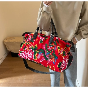 Large travel bag with red floral dragon patterns and adjustable shoulder strap
