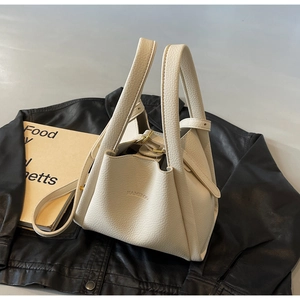 Detail of cream lychee leather bucket bag with HAMIROO logo and metal buckle