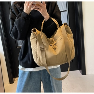 Close-up of khaki nylon tote bag with adjustable strap shown on model for daily commute