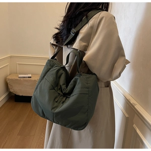Olive green nylon tote bag featuring reinforced handles and adjustable shoulder strap