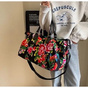 Detail of large capacity travel bag with traditional floral print and durable leather handles
