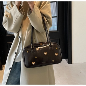 Detail of vintage coffee leather handbag with gold heart crystal and rivet accents