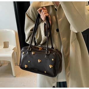 Detail of dark brown vintage handbag with gold heart studs and sparkling rhinestones