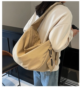 Detail of khaki canvas hobo bag with wide shoulder strap and matching coin purse attachment