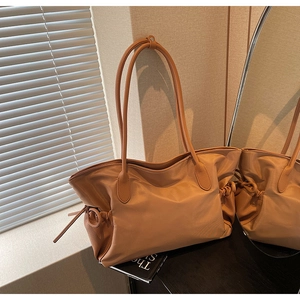 Détail du sac cabas en cuir caramel avec plis latéraux à cordon et longues anses