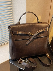 Vintage dark brown leather backpack with metal buckles and top handle for women