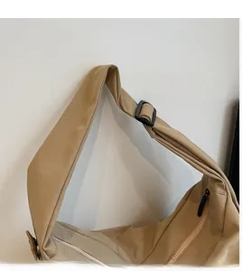 Detail view of khaki canvas crossbody bag with adjustable strap and durable black buckle