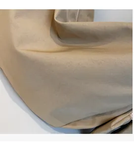 Close-up of durable khaki canvas fabric texture on a large capacity crossbody bag