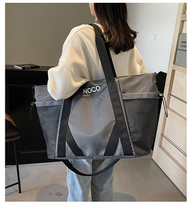 Bolso de viaje gris grande con bolsillo lateral de malla y logo NOCO visto de lado