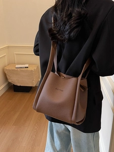 Brown litchi grain leather bucket bag with top handle and HANTROO logo shown on a model