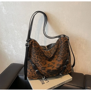Detailed macro view of leopard print canvas texture and black leather shoulder strap