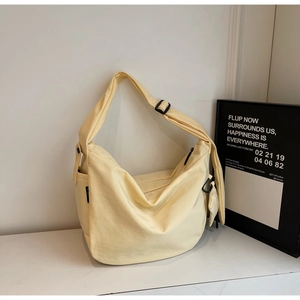 Detail of canvas crossbody bag with side pocket, adjustable strap and mini coin purse