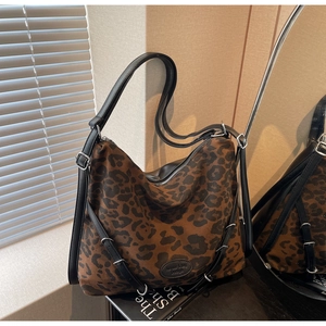 Macro shot of leopard print tote bag with black strap and silver metal buckle detail