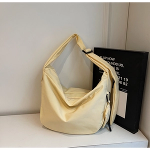 Detail of light yellow canvas hobo bag with a matching mini pouch and adjustable strap