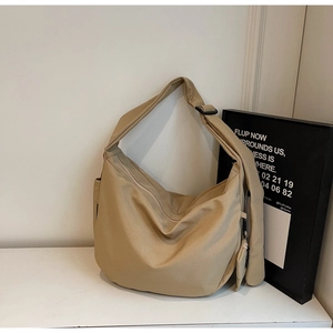 Detail of khaki large canvas shoulder bag with pleated design and mini coin purse charm