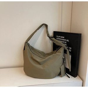 Close-up of military green large canvas crescent bag with detachable mini zip pouch