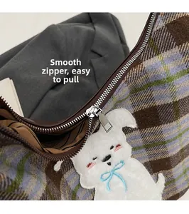 Close-up of smooth silver zipper and detailed puppy embroidery on plaid tweed tote bag