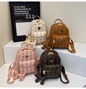 Detailed display of four mini backpacks in beige, brown, and pink with teddy bear prints