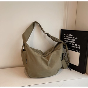 Detail of khaki canvas crossbody bag with wide shoulder strap and mini pouch attachment