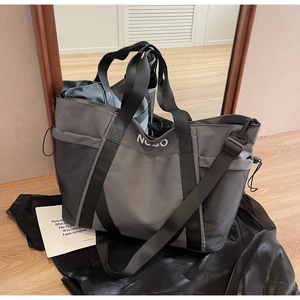 Detalle de bolsa de deporte gris en nailon con bolsillo de malla y correa ajustable