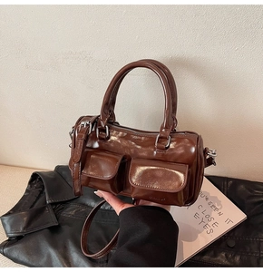 Detail of vintage brown leather bowling bag showing silver zippers and front flap pockets