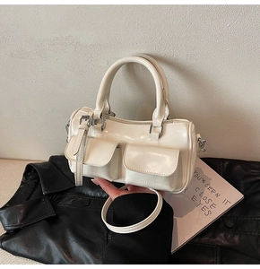 Detail view of cream Boston bag with dual pockets and embossed CLEAROK logo