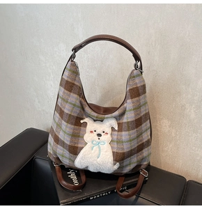 Close-up of retro plaid fabric tote with a cute plush cartoon dog patch and brown handles
