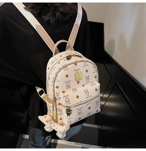 Detail of cream mini backpack with cartoon bear print and matching teddy charm pendant