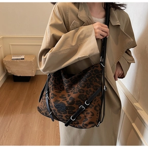 Hobo bag featuring classic leopard print on canvas with leather straps and silver buckle