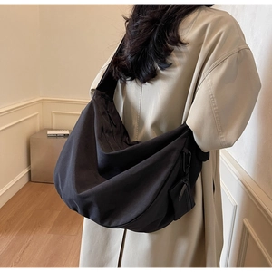 Detail of a large black canvas dumpling bag showing the side view and matching coin purse