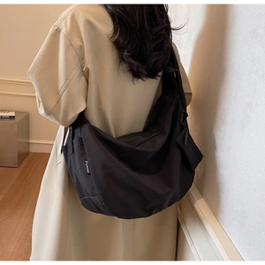 Model wearing a large black crescent canvas bag showing spacious size and casual style