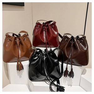 Détail de sacs seaux plissés en quatre couleurs avec cordon et détails de glands