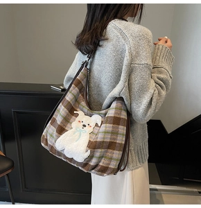 Detail of checkered tote bag with puppy patch on a model in a modern interior setting