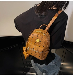 Close-up of caramel mini backpack with teddy bear print and matching bear charm