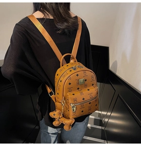 Close-up of brown teddy bear print backpack with a cute dog leather charm detail