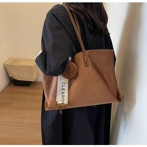 Detail of brown suede tote bag with CLEAR letter ribbon and matching mini round coin purse