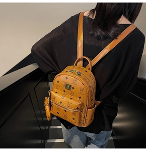 Close-up of brown faux leather backpack with teddy bear pattern and adjustable straps