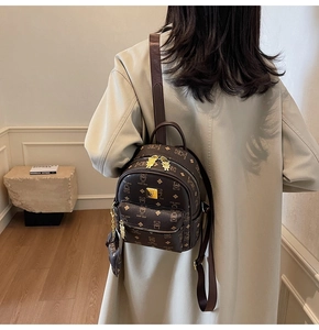 Detail view of brown faux leather backpack with vintage bear print and scarf ornament