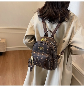 Detail of Teddy Bear pattern on dark brown leather backpack with gold metal zipper