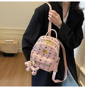 Pink mini leather backpack with teddy bear prints and hanging charm on model
