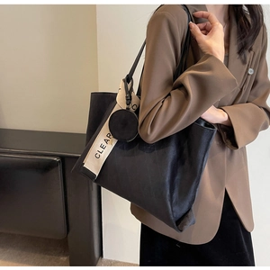Detail of black suede tote bag with CLEAR lettered strap and small round coin purse